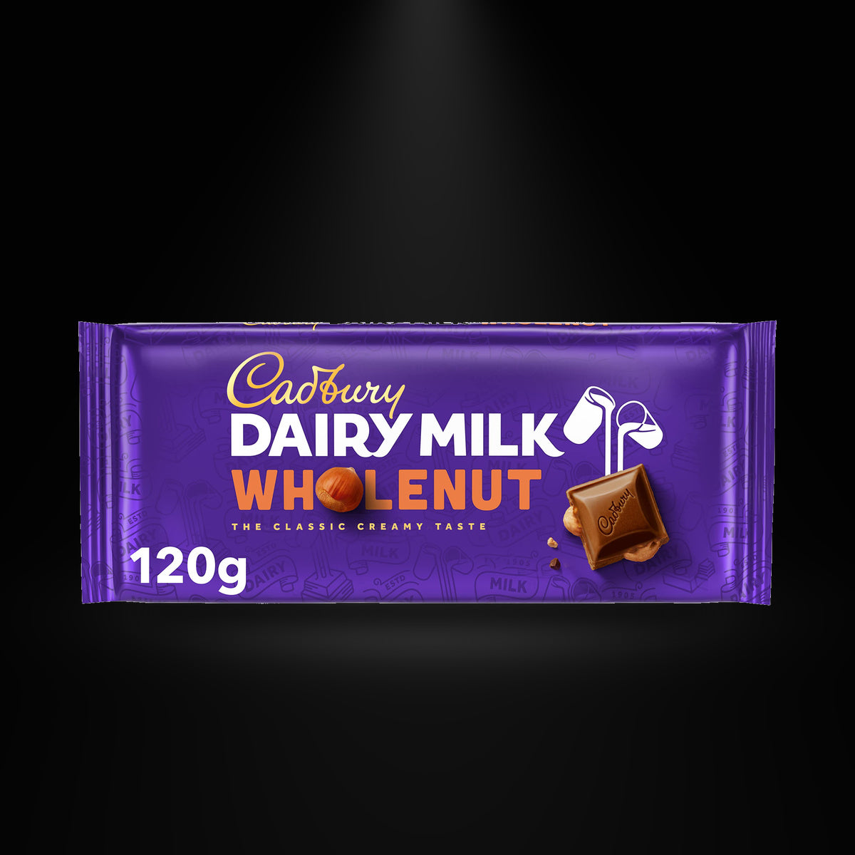 CA Dairymilk Wholenut 120gm on a black background with an overhead spotlight