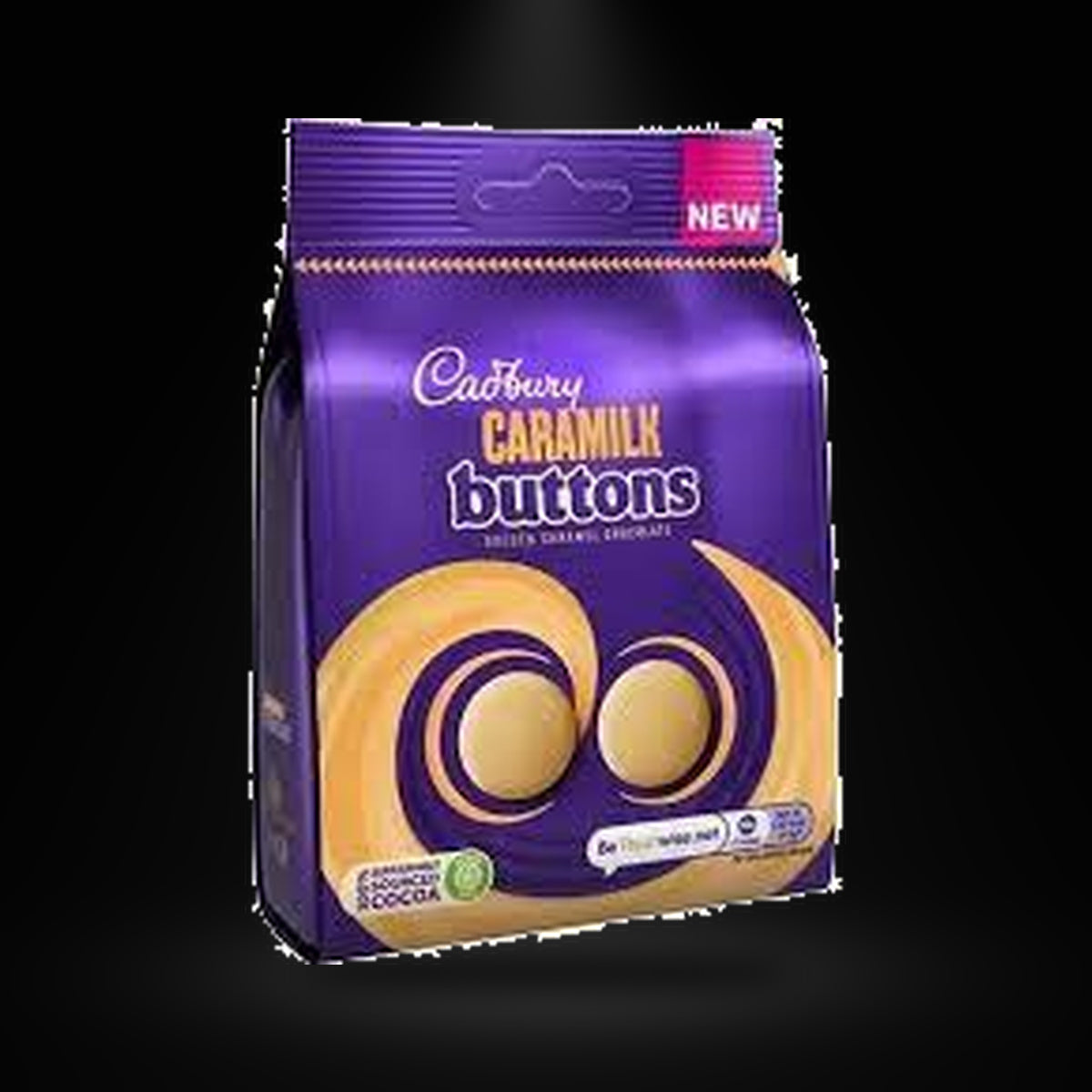 Cadbury Caramilk Buttons 100g on a black background with an overhead spotlight