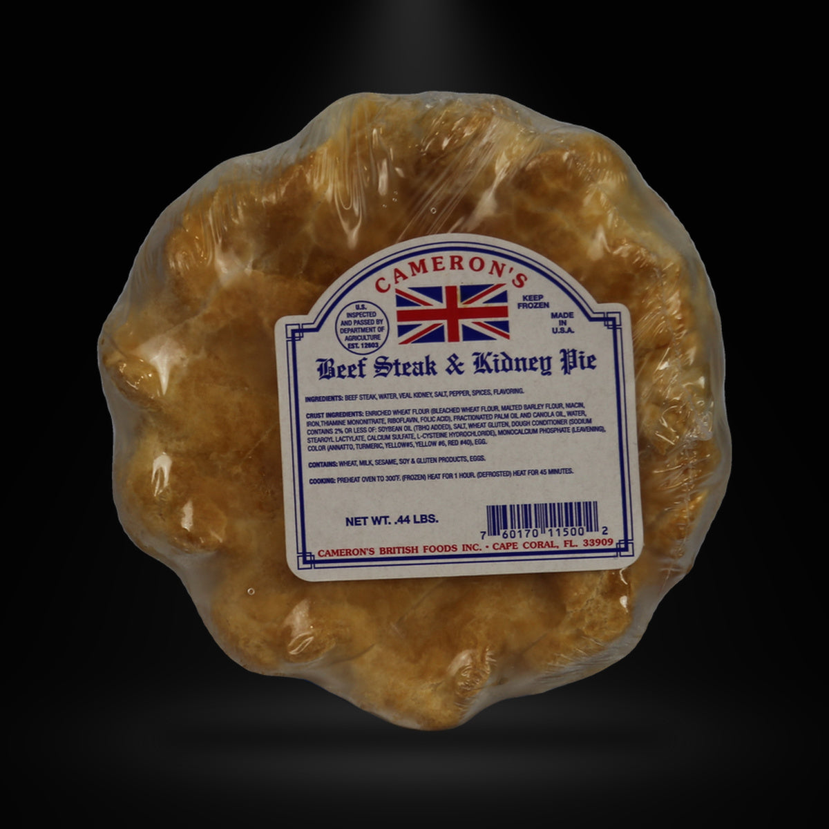 Cameron Beef n kidney pie on a black background with an overhead spotlight