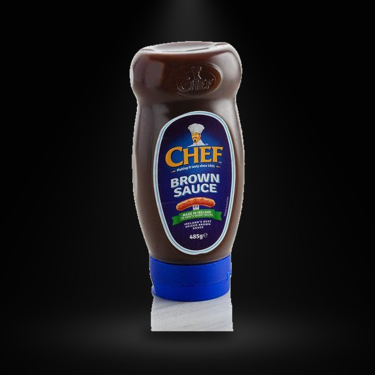 Chef brown sauce 485gm on a black background with an overhead spotlight