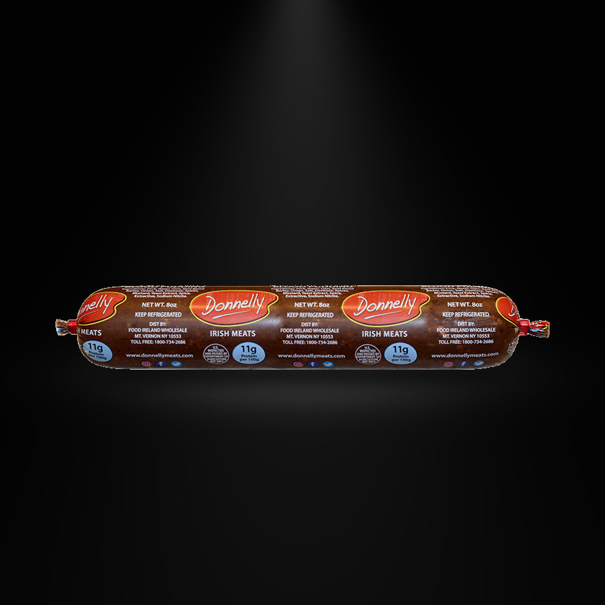 Donnelly black pudding on a black background with an overhead spotlight