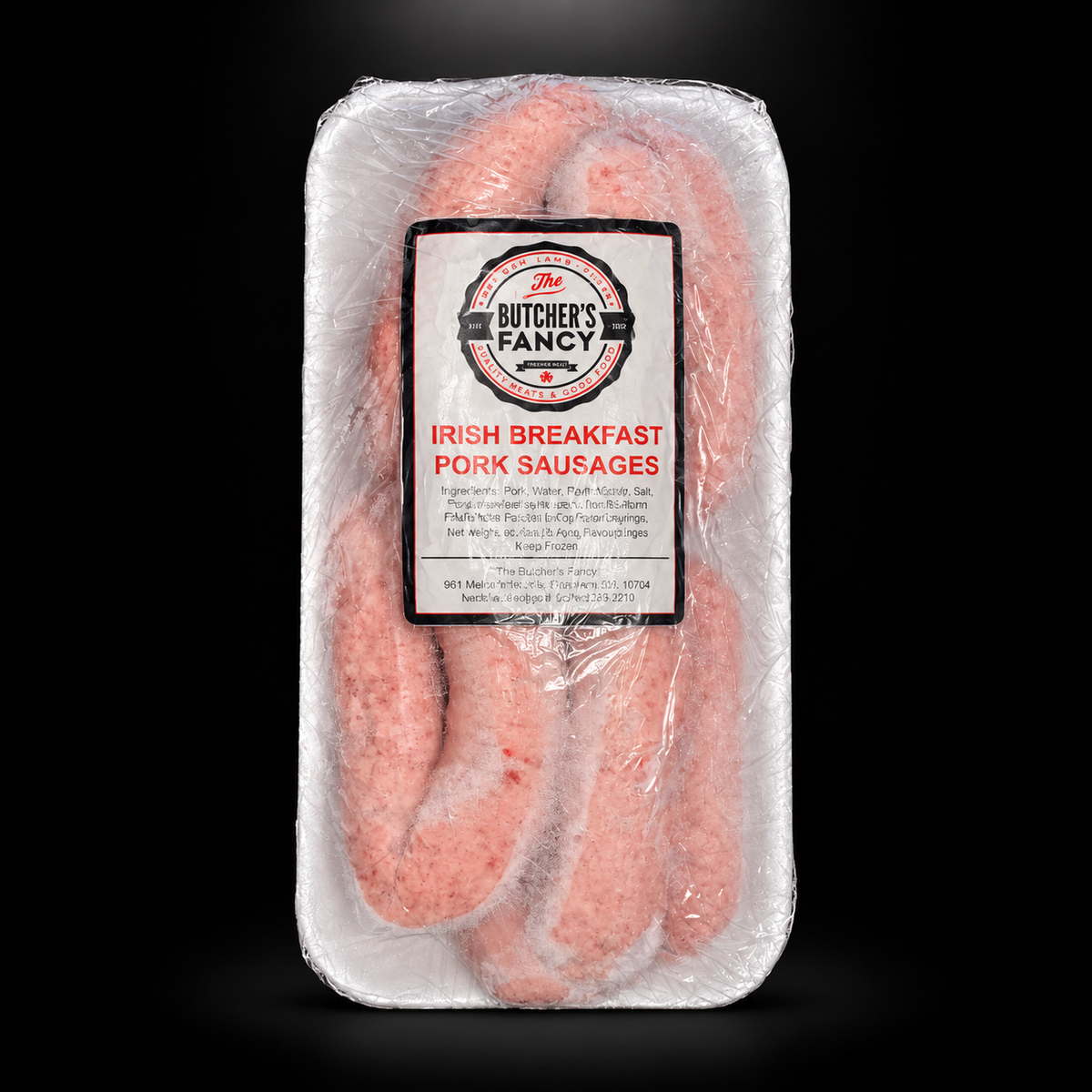 Butcher's Fancy Breakfast Pork Sausages — black background with overhead spotlight