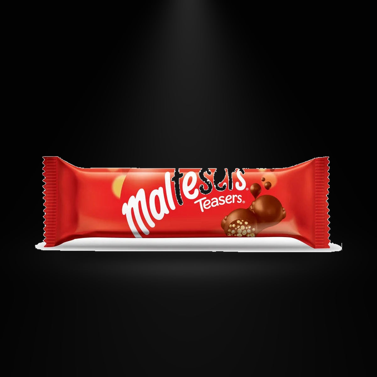 Maltesers Teasers 35gm on a black background with an overhead spotlight