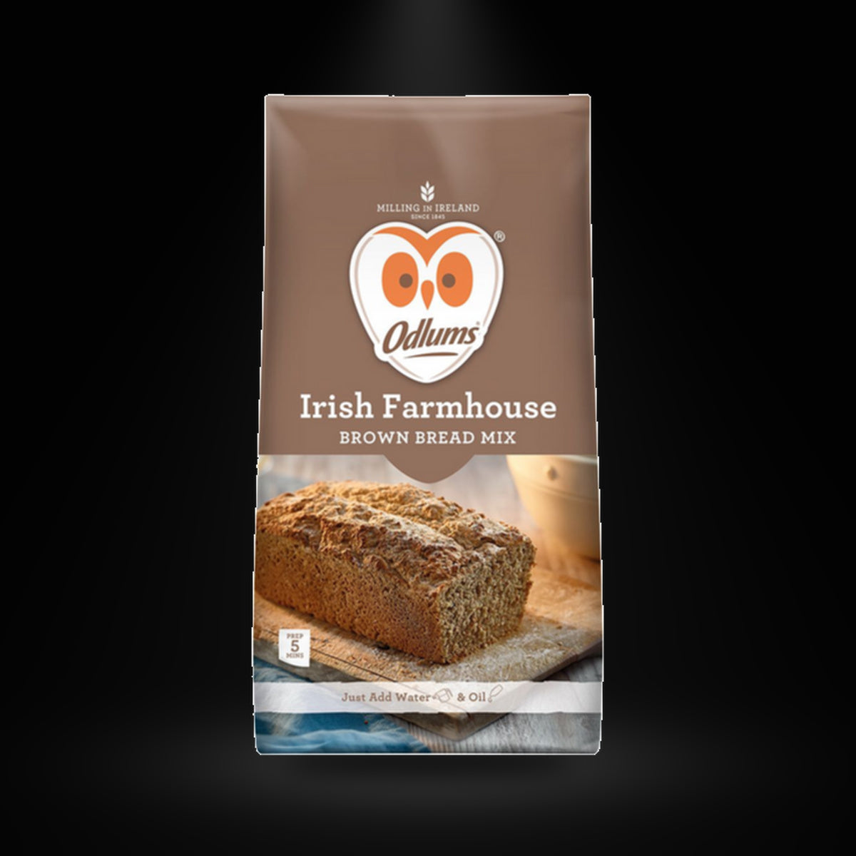 Odulms Farmhouse Brown Bread on a black background with an overhead spotlight